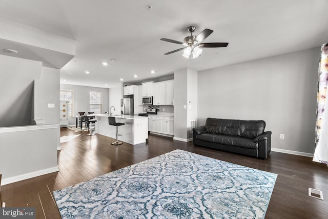 living room with ceiling fan, dark hardwood / wood-style flooring, and sink