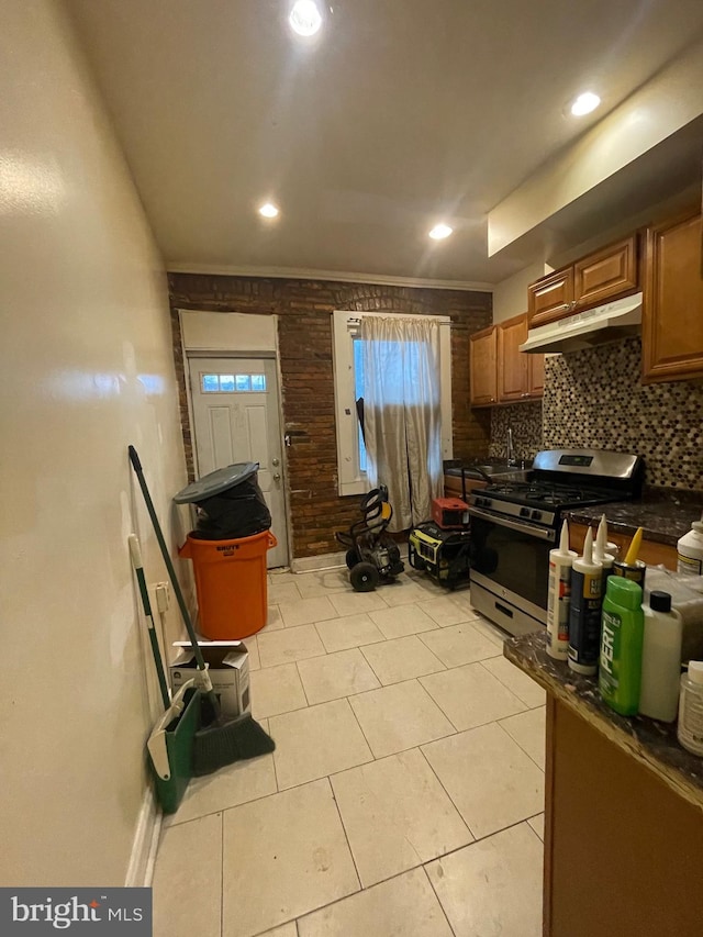 kitchen with backsplash, crown molding, light tile patterned flooring, and stainless steel range with gas stovetop