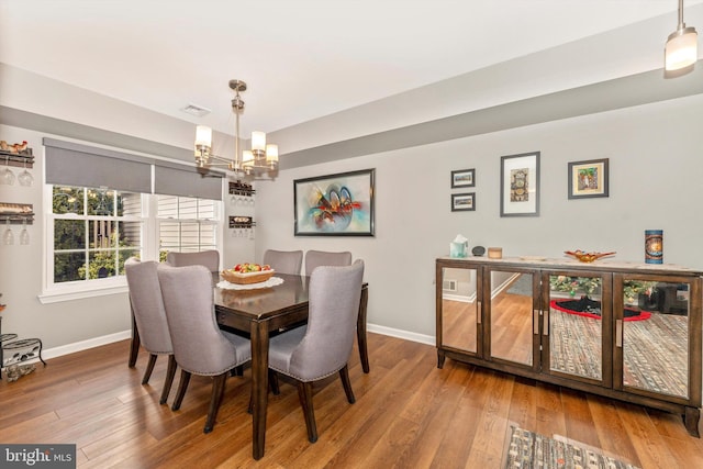 dining space featuring a notable chandelier and hardwood / wood-style flooring