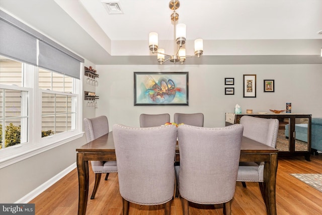 dining space with an inviting chandelier and light hardwood / wood-style floors