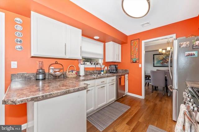 kitchen featuring sink, light hardwood / wood-style flooring, white cabinets, and appliances with stainless steel finishes