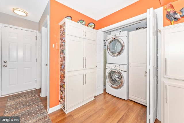 clothes washing area featuring stacked washer / dryer and light wood-type flooring