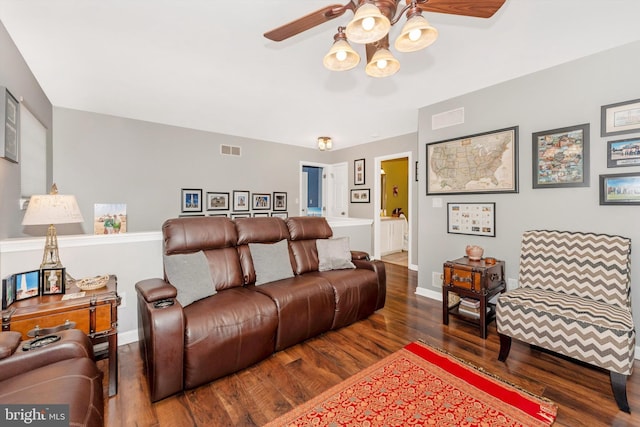 living room featuring dark wood-type flooring and ceiling fan