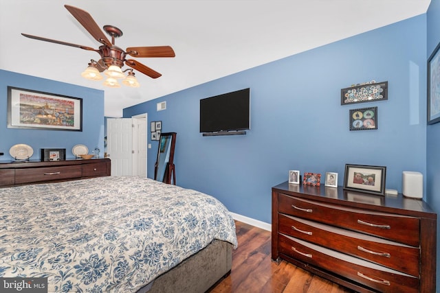 bedroom with dark hardwood / wood-style flooring and ceiling fan