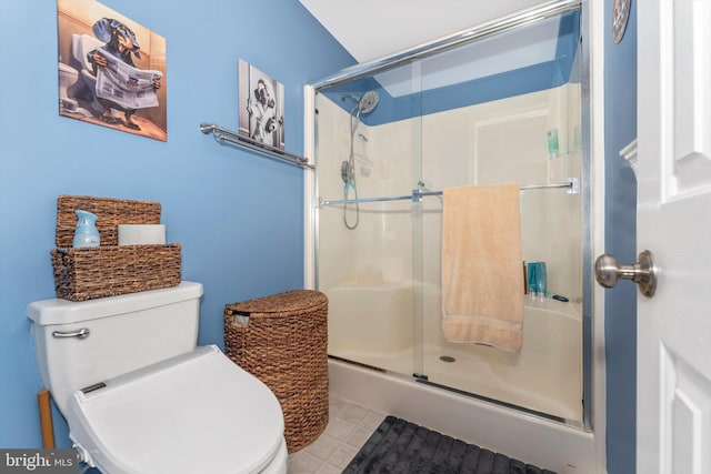 bathroom featuring toilet, tile patterned flooring, and a shower with door