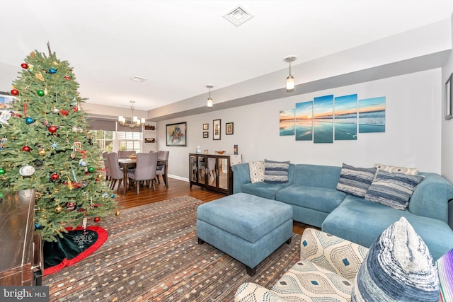 living room with hardwood / wood-style floors and a notable chandelier