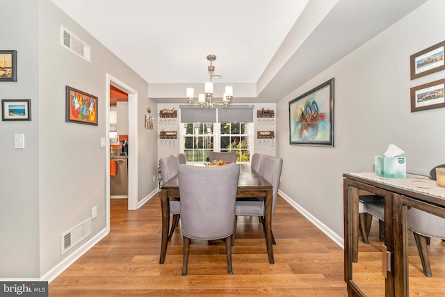 dining room featuring a chandelier and light wood-type flooring