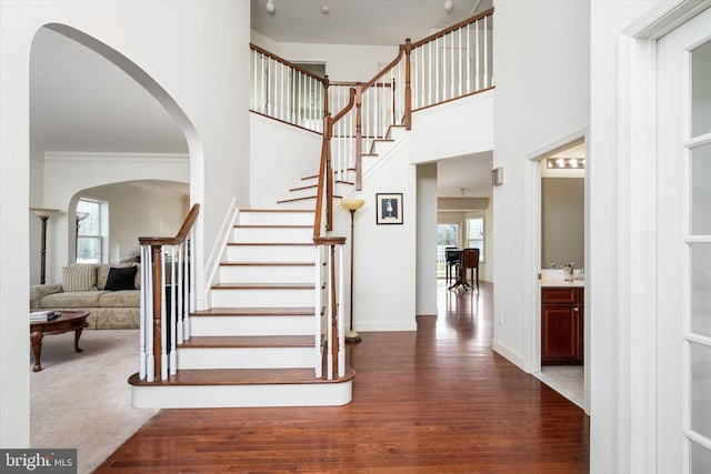 stairs featuring hardwood / wood-style flooring, plenty of natural light, and ornamental molding