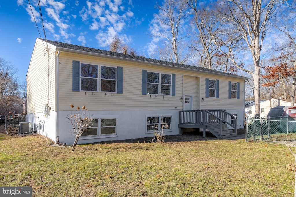 rear view of property featuring a wooden deck, a yard, and central AC unit