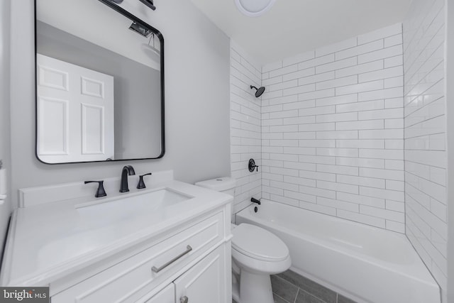 full bathroom featuring toilet, vanity, and tiled shower / bath