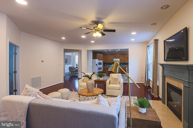 living room featuring dark wood-type flooring and ceiling fan