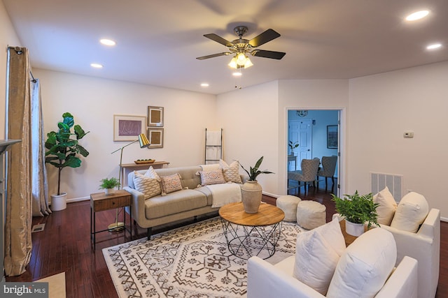 living room featuring ceiling fan and dark hardwood / wood-style floors