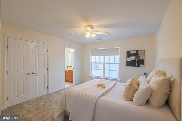 bedroom featuring light carpet, ceiling fan, and ensuite bathroom