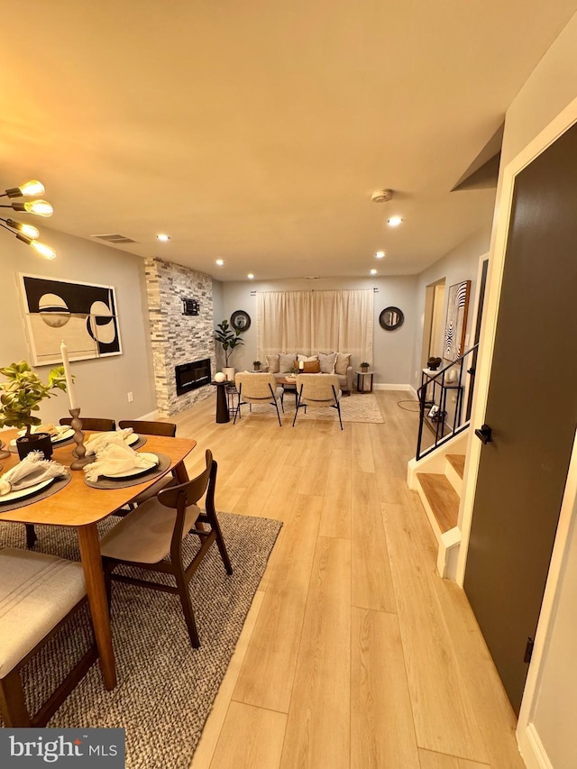 dining area featuring a fireplace and light wood-type flooring