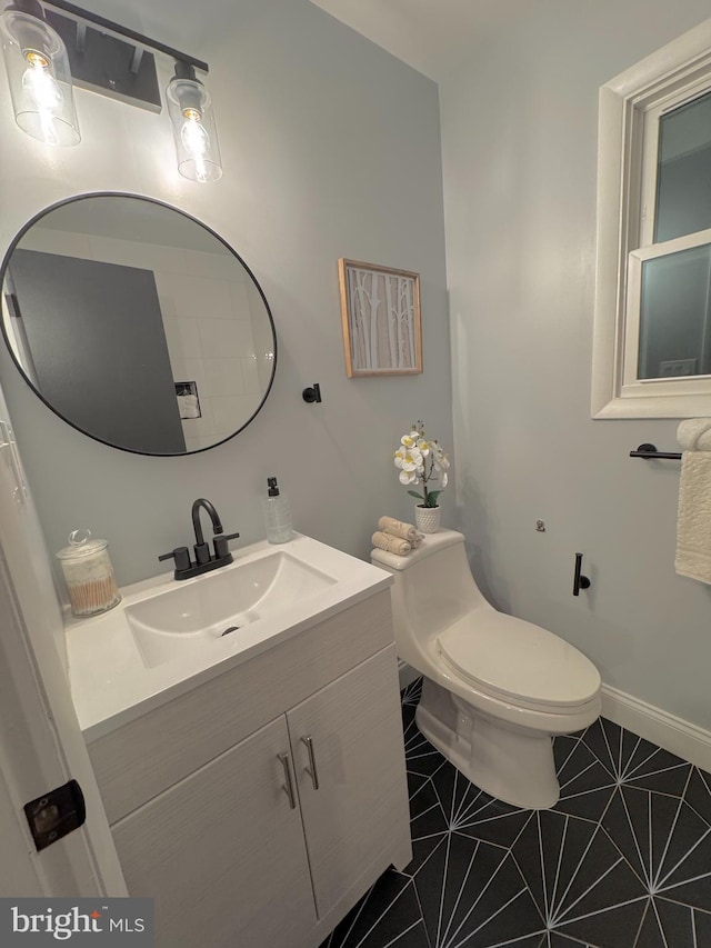 bathroom with tile patterned flooring, vanity, and toilet