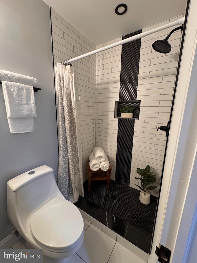 bathroom with tile patterned flooring, toilet, and walk in shower