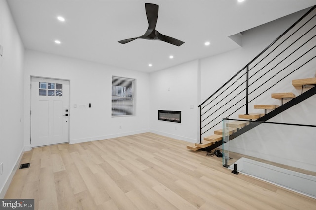 unfurnished living room with light wood-type flooring and ceiling fan