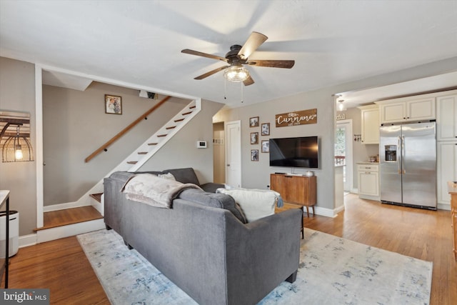 living room featuring ceiling fan and light hardwood / wood-style flooring