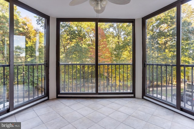 unfurnished sunroom featuring ceiling fan