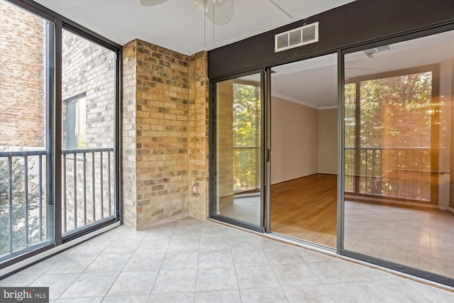 entryway with expansive windows, a healthy amount of sunlight, light tile patterned floors, and ceiling fan