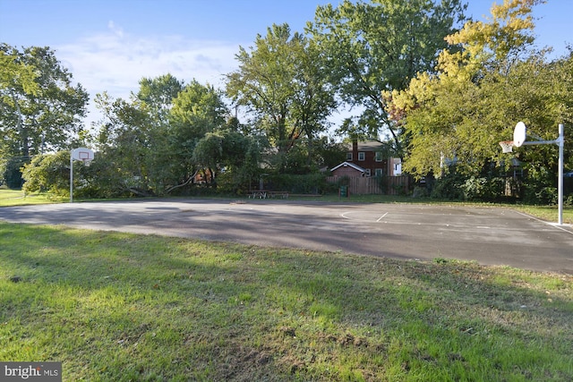 view of sport court featuring a lawn