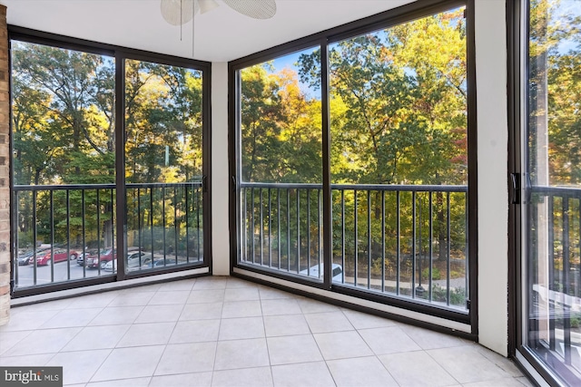 unfurnished sunroom with a wealth of natural light and ceiling fan