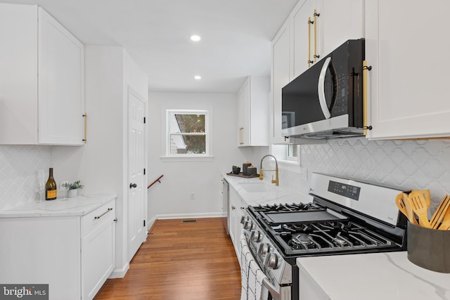 kitchen featuring light stone countertops, white cabinetry, and stainless steel appliances