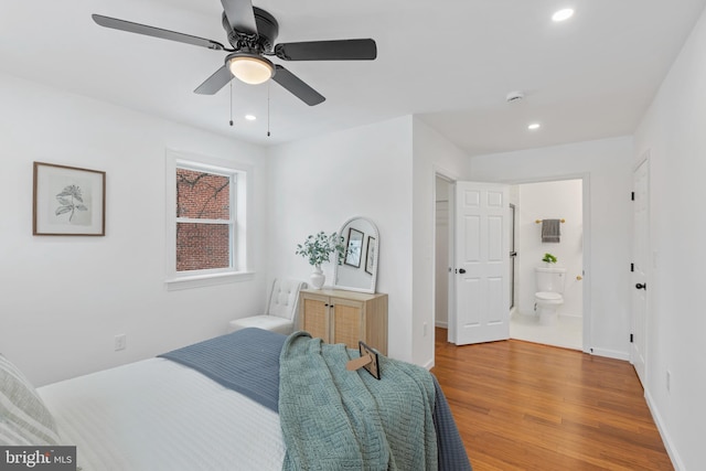 bedroom with hardwood / wood-style floors, connected bathroom, and ceiling fan