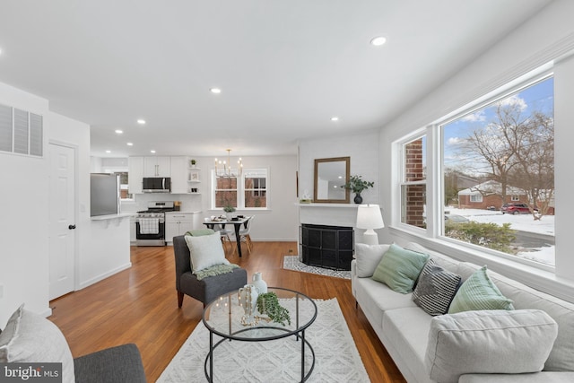 living room with a chandelier and light wood-type flooring