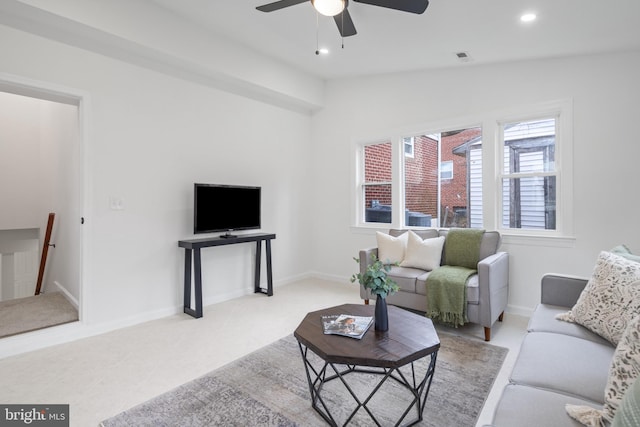 living room with ceiling fan, light colored carpet, and lofted ceiling