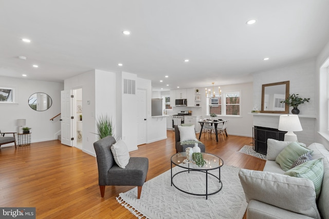 living room with a chandelier and light hardwood / wood-style flooring