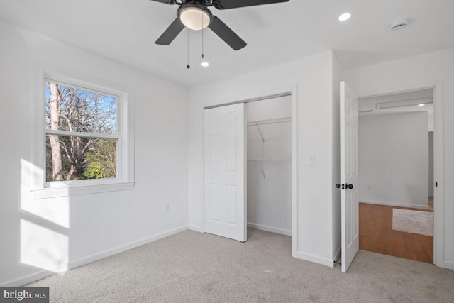 unfurnished bedroom with ceiling fan, light carpet, and a closet