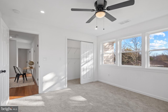 unfurnished bedroom featuring ceiling fan, a closet, and light colored carpet