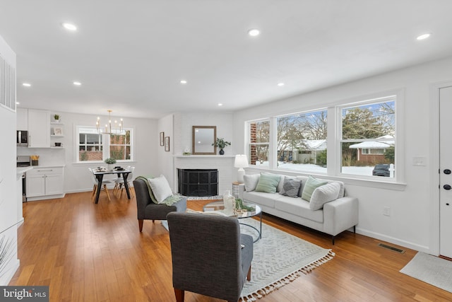 living room featuring light hardwood / wood-style floors and an inviting chandelier