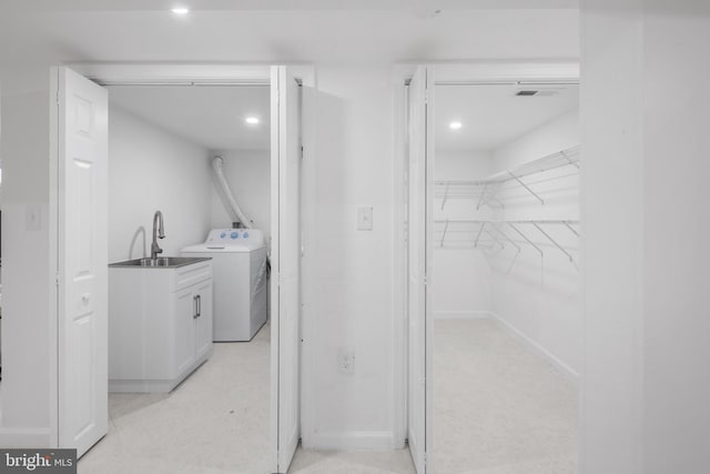 clothes washing area with washer / dryer and sink