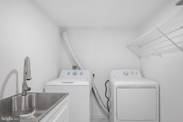 washroom with washer and dryer, cabinets, and sink