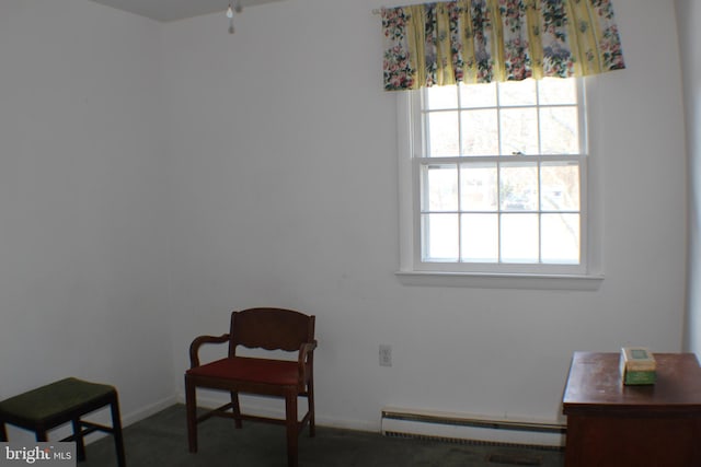 living area featuring baseboard heating and dark colored carpet