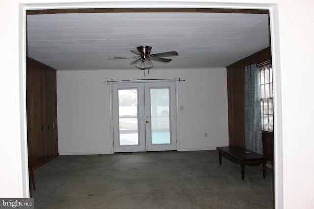 interior space featuring ceiling fan, french doors, and wooden walls