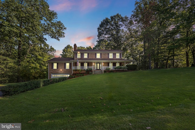 colonial home featuring a lawn and a porch