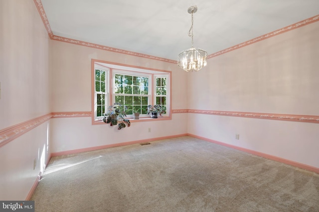 empty room featuring carpet floors and a notable chandelier