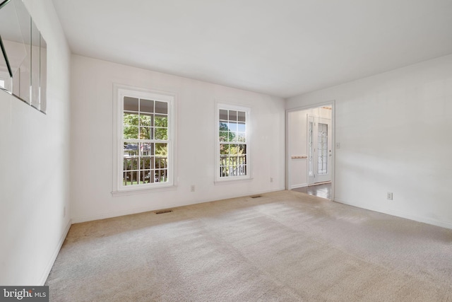 unfurnished room featuring light carpet