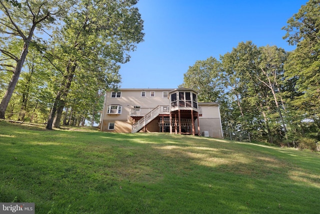 back of house with a sunroom, an AC wall unit, a yard, a wooden deck, and central AC