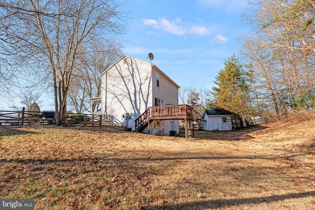 view of property exterior with a wooden deck and a shed