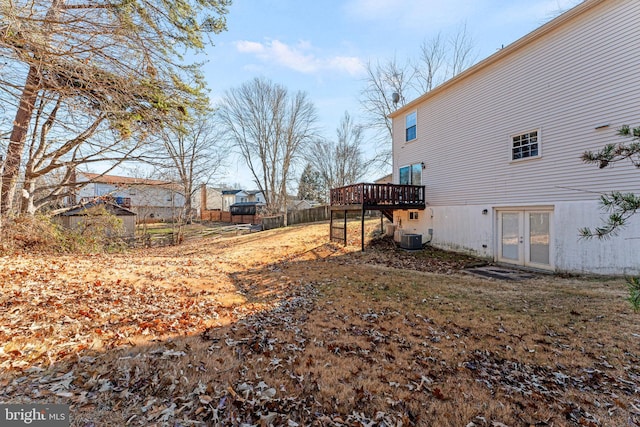 view of yard featuring a deck, french doors, and central air condition unit