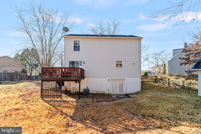 rear view of property featuring french doors, a yard, central air condition unit, and a wooden deck