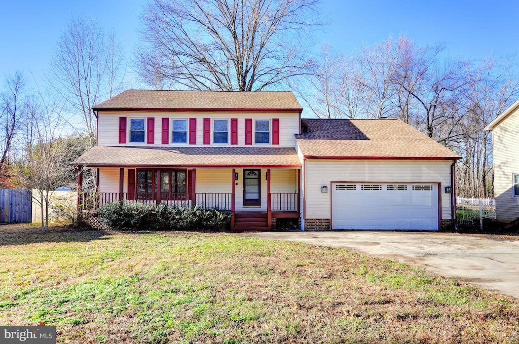 view of front of property featuring a front lawn, a porch, and a garage