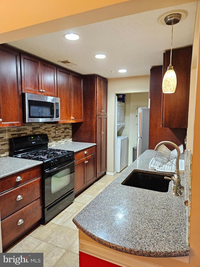 kitchen with pendant lighting, sink, appliances with stainless steel finishes, tasteful backsplash, and stone countertops