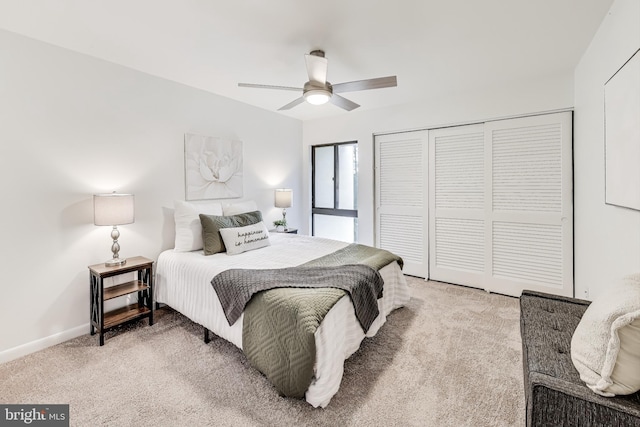 carpeted bedroom with ceiling fan and a closet