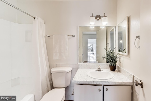 full bathroom featuring vanity, tile walls, shower / bathtub combination with curtain, and toilet