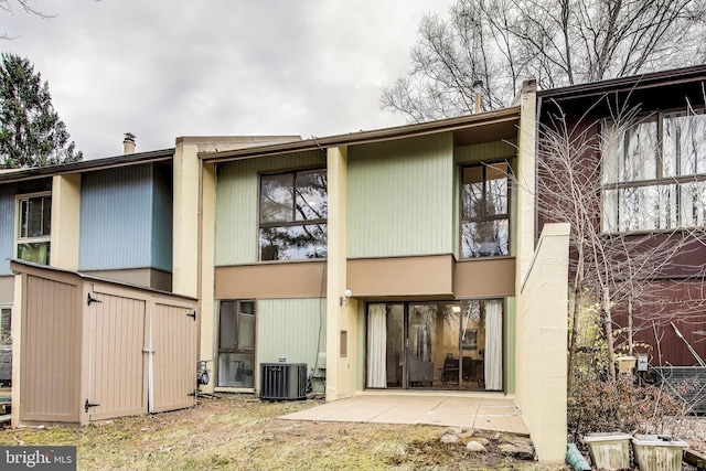 rear view of house with central AC and a patio area